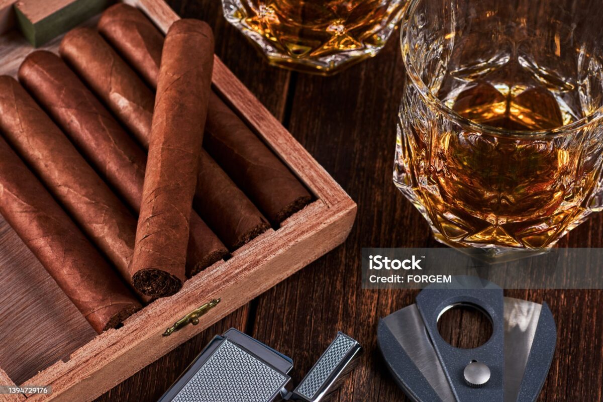 An open box of cigars on a dark wooden table
