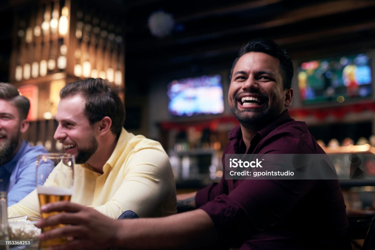 Friends laughing together while watching a game
