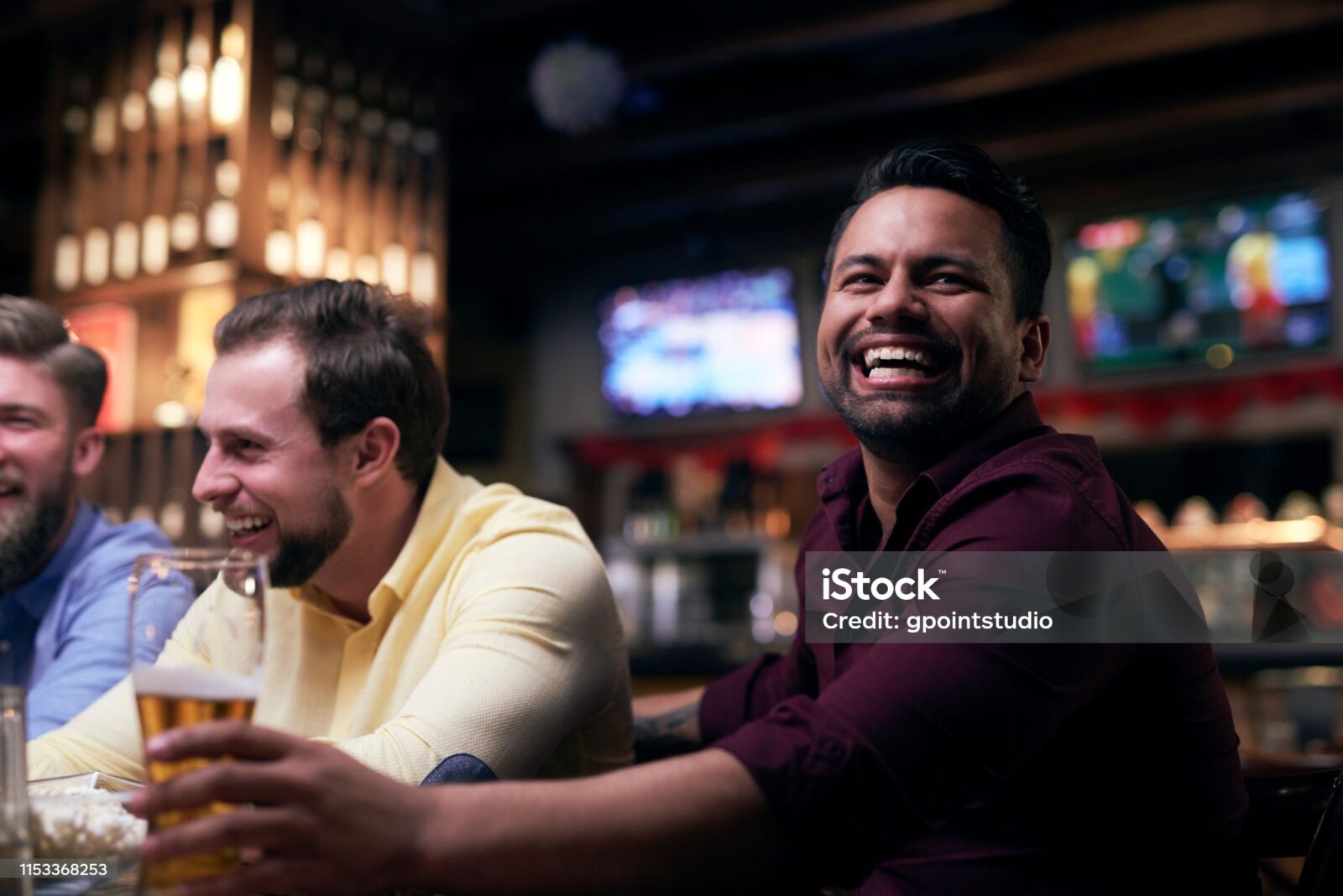 Friends laughing together while watching a game
